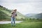 Young hipster man in a straw hat with a backpack travels the green mountains, text spase