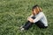 Young hipster woman, sad, long-haired sitting hugging legs.