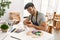 Young hispanic artist man smiling happy painting pottery at art studio