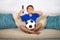 Young hispanic boy happy and excited watching football game on television at home living room couch celebrating scoring goal gestu