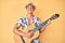 Young hispanic boy wearing summer style playing classical guitar smiling with a happy and cool smile on face