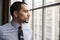 Young Hispanic business man looking out of window