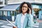 Young hispanic business woman wearing professional look smiling confident at the city holding worker clipboard