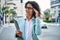 Young hispanic business woman wearing professional look smiling confident at the city holding worker clipboard