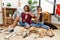 Young hispanic couple doing laundry with dogs doing time out gesture with hands, frustrated and serious face