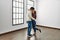 Young hispanic couple kissing and hugging standing at empty new home
