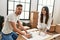 Young hispanic couple smiling happy unpacking cardboard box at new home