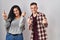 Young hispanic couple standing over white background showing middle finger doing fuck you bad expression, provocation and rude