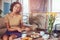 Young Hispanic curly girl having breakfast at home sitting on the sofa.