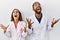 Young hispanic doctors standing over white background crazy and mad shouting and yelling with aggressive expression and arms