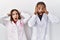 Young hispanic doctors standing over white background crazy and scared with hands on head, afraid and surprised of shock with open