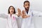 Young hispanic doctors standing over white background doing stop gesture with hands palms, angry and frustration expression