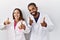 Young hispanic doctors standing over white background pointing fingers to camera with happy and funny face