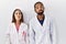 Young hispanic doctors standing over white background puffing cheeks with funny face