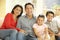 Young Hispanic Family Relaxing On Sofa At Home