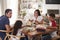 Young Hispanic family sitting at dining table eating dinner together