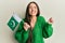 Young hispanic girl holding pakistan flag screaming proud, celebrating victory and success very excited with raised arm