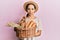 Young hispanic girl holding wicker basket with bread relaxed with serious expression on face