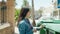 Young hispanic girl smiling confident recycling plastic at street