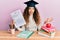 Young hispanic girl wearing graduated hat holding passed test celebrating achievement with happy smile and winner expression with