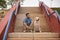 Young Hispanic male, sitting on stairs next to his dog as they both look in the same direction. Concept, dogs, pets, animals,