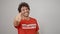 Young hispanic man activist wearing volunteer uniform pointing to camera over isolated white background