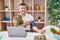 Young hispanic man army soldier using tensiometer at home