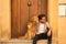 Young Hispanic man with beard and sunglasses sitting next to his dog on the front step of a house, very happy. Concept animals,