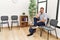 Young hispanic man boring sitting on chair at waiting room