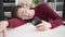 Young hispanic man business worker using smartphone tired sleeping on table at office