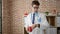 Young hispanic man doctor drinking coffee looking watch smiling at the clinic