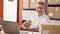 Young hispanic man ecommerce business worker using laptop smiling at office