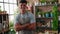 Young hispanic man florist smiling confident standing with arms crossed gesture at flower shop