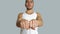 Young hispanic man with hair pulled up bun in white sleeveless t-shirt, looking towards camera with aggressive attitude