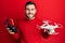 Young hispanic man holding drone and remote control with smartphone smiling with a happy and cool smile on face
