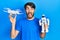 Young hispanic man holding drone and robot toy celebrating crazy and amazed for success with open eyes screaming excited