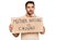 Young hispanic man holding mother nature is crying protest cardboard banner serious face thinking about question with hand on