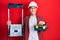 Young hispanic man holding tools box wearing hardhat by construction stairs celebrating crazy and amazed for success with open