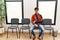 Young hispanic man injuried sitting on chair at clinic waiting room