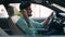 Young hispanic man listening voice message by smartphone sitting on car at street