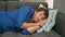 Young hispanic man lying on sofa sleeping at home