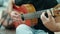 Young hispanic man musician playing classical guitar sitting on bench at park