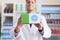 Young hispanic man pharmacist smiling confident holding medication package at pharmacy