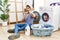 Young hispanic man putting dirty laundry into washing machine doing time out gesture with hands, frustrated and serious face