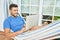 Young hispanic man relaxed working using laptop lying on the hammock at terrace