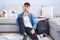 Young hispanic man sitting on the floor studying for university thinking concentrated about doubt with finger on chin and looking