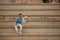 Young Hispanic man, sitting on large cement stairs next to his dog looking both in the same direction. Concept, dogs, pets,