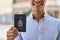 Young hispanic man smiling confident holding canada passport at street