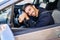 Young hispanic man smiling confident leaning on steering wheel at street