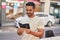 Young hispanic man smiling confident reading passport at street